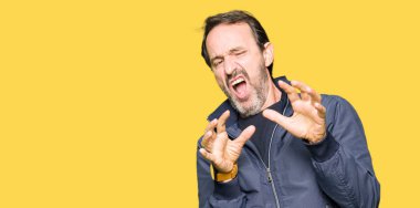 Bir ceket giyen orta yaş yakışıklı adam tiksinti ifadesi, memnun ve korkulu tiksinti yüz yapıyorsun çünkü nefret tepki. Elleriyle kaldırdı. Sinir bozucu kavramı.