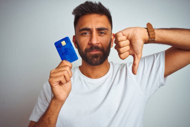 Genç hint müşteri adam kızgın yüz ile izole beyaz arka plan üzerinde duran kredi kartı tutan, başparmak aşağı, ret kavramı ile sevmediğimi gösteren negatif işareti