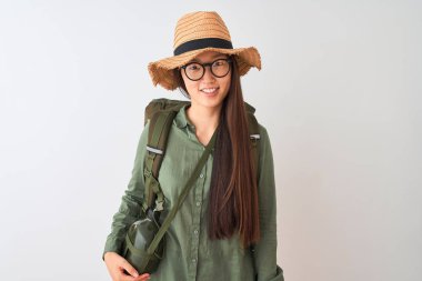 Çinli yürüyüşçü kadın yüzünde mutlu ve serin bir gülümseme ile izole beyaz arka plan üzerinde kantin şapka gözlük sırt çantası giyiyor. Şanslı kişi.