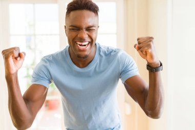 Afrika kökenli Amerikalı adam çok heyecanlı ve kutluyor başarı ve zafer, çığlık happpy gülümseyerek ve neşeli
