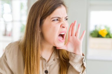 El ağızdan bağırarak ve ile yan için çığlık güzel genç kadın evde. İletişim kavramı.