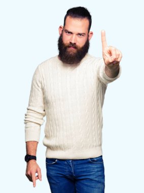 Kış kazak giyen genç hipster adam işaret parmağını ve kızgın ifade ile