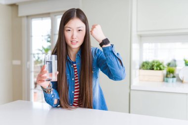 Güzel Asyalı kadın kızgın ve sinirli öfke, deli ve yükseltilmiş el, öfke kavramı ile bağırarak bir bardak içme