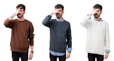 Izole arka plan üzerinde bir kazak giyen genç adamın kolaj şok yüz ve gözleri el ile kaplayan gözetleme, utanmış ifade ile parmaklarından bakarak.