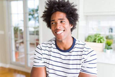 Çizgili t-shirt giyen Afro-Amerikan adam yan görünümlü ve düşünme uzağa bakıyor.