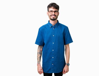 Yüzünde mutlu ve güzel bir gülümseme ile izole arka plan üzerinde gözlük takan yakışıklı delikanlı. Şanslı kişi.