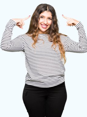 Çizgili kazak giyen genç güzel kadın Gülümseyerek iki eliyle parmak, harika bir fikir ya da düşünce, iyi bellek ile baş işaret