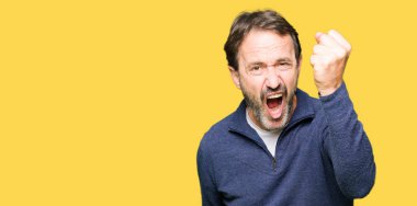 Orta yaş yakışıklı adam kızgın ve kızgın hayal kırıklığı ve öfke ile bağırarak süre öfkeli yumruk yükselterek bir kazak giyiyor. Öfke ve agresif kavramı.