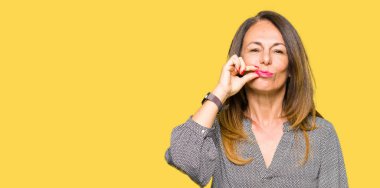 Güzel orta yaş iş kadın ağız ve dudaklar parmak ile ZIP olarak kapatın. Gizli ve sessiz, tabu söz