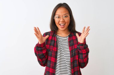 Genç Çinli kadın t-shirt ceket ve gözlük giyen izole beyaz arka plan üzerinde deli kutluyor ve kollarını kaldırdı ve açık gözleri heyecan çığlık ile başarı için hayran. Kazanan kavramı