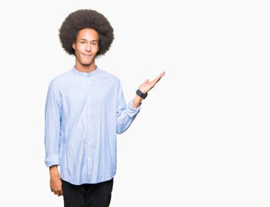 Neşeli sunulması ve kameraya bakarak avucunun ile işaret gülümseyen afro saçlı genç Afro-Amerikan adam.