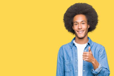 Afrikalı-Amerikalı genç afro saçlı hareketi el ile mutlu yaşasın yapıyor. Başarı gösteren kameraya bakarak ifade onaylama.