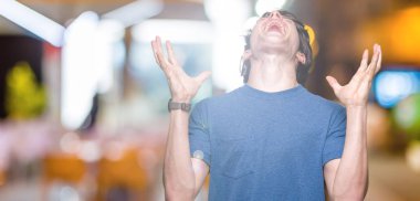 Yakışıklı delikanlı deli ve silah ile başarı için deli kutluyor izole arka plan üzerinde mavi t-shirt giyen kaldırdı ve heyecanlı çığlık gözler kapalı. Kazanan kavramı