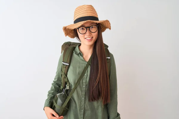 Chinese hiker woman wearing canteen hat glasses backpack over isolated white background with a happy and cool smile on face. Lucky person.