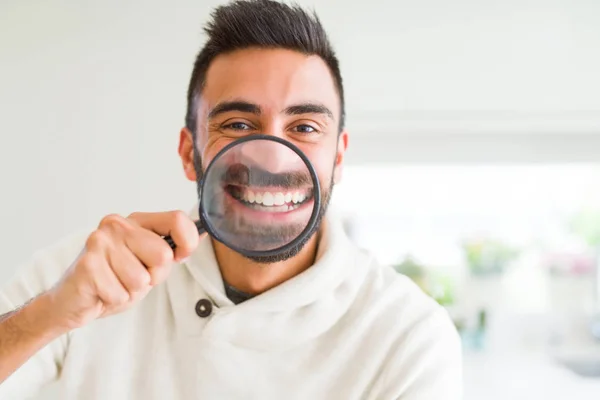 Handsome man using magnifying glass, doing funny faces — Stock Photo, Image