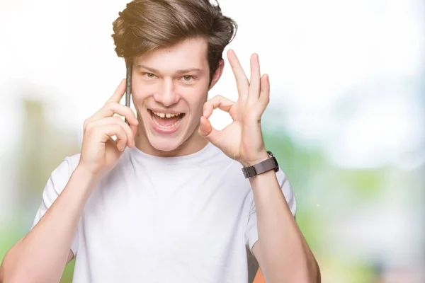 Młody Człowiek Mówi Smartphone Białym Tle Robi Znak Palcami Doskonały — Zdjęcie stockowe