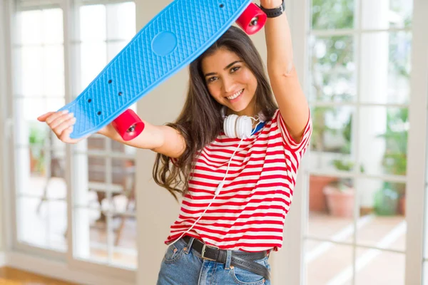 Hermosa mujer skater sonriendo amistoso de pie con monopatín —  Fotos de Stock