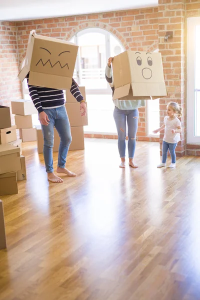 Yeni evde karton bel kutuları ile oynayan çocuk ile güzel famiily