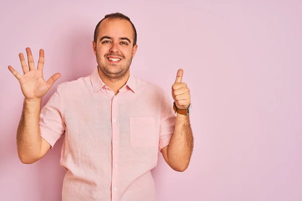 穿着优雅衬衫的年轻人站在孤立的粉红色背景显示和指着手指六 同时微笑自信和快乐 — 图库照片