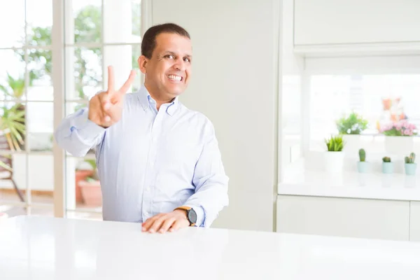 Hombre Mediana Edad Sentado Casa Sonriendo Mirando Cámara Mostrando Los — Foto de Stock