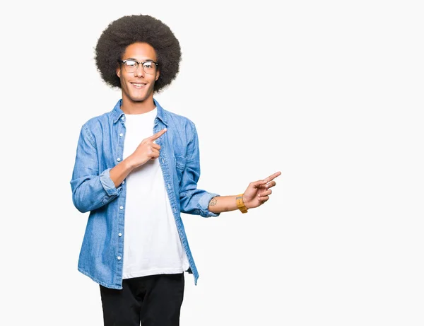 Молодой Африканский Американец Афроволосами Очках Улыбается Смотрит Камеру Указывая Двумя — стоковое фото