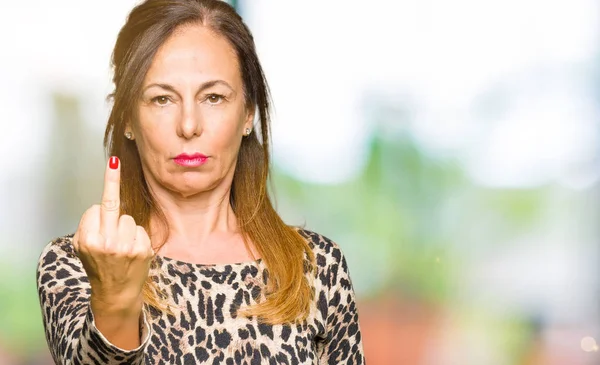 Beautiful middle age woman wearing leopard animal print dress Showing middle finger, impolite and rude fuck off expression