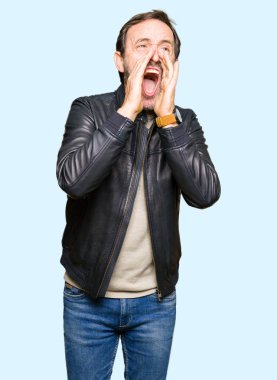 Siyah deri ceket ağzına sesle elleriyle kızgın bağırarak giyen orta yaş yakışıklı adam
