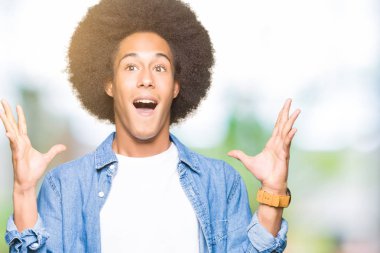 Afrikalı-Amerikalı genç afro saç kaldırdı kollarını açarak deli ve başarı için hayran kutluyor ve açık gözleri heyecanlı çığlık. Kazanan kavramı