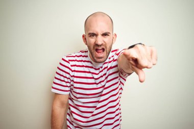 Sakallı genç kel adam beyaz izole arka plan üzerinde rahat çizgili kırmızı t-shirt giyen hoşnut olmayan ve kameraya sinirli işaret, kızgın ve öfkeli