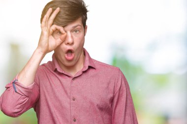 Genç yakışıklı iş adamı ok jest yapıyor izole arka plan üzerinde sürpriz yüz, göz parmaklarının arasından seyir ile şok. İmansız ifade.