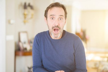 Yakışıklı orta yaş adam evde korkmuş ve sürpriz ifade, korku ve heyecanlı yüz ile şok.