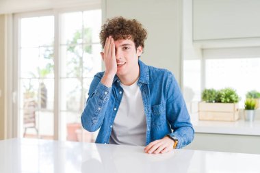 Evde rahat kot ceket giyen genç yakışıklı adam yüzünde kendinden emin bir gülümseme ve sürpriz duygu ile bir göz kapsayan.