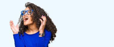 Genç güzel kadın kıvırcık saçlı gözlüklü çılgın ve deli bağırarak ve agresif ifade ve silah kaldırdı bağırıyor. Hayal kırıklığı kavramı.