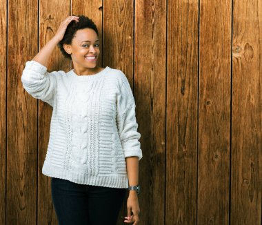 Güzel genç Afro-Amerikan kadın giyiyor kazak izole arka plan üzerinde yanıltır ve soru hakkında merak ediyorum. Şüphe, kafasına el ile düşünme ile belirsiz. Dalgın kavramı.