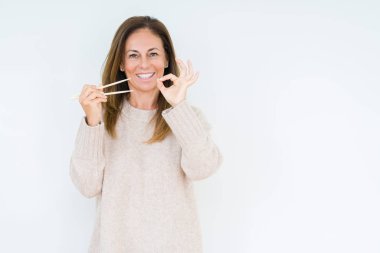 Orta yaş kadın parmakları ile ok işareti yapıyor izole arka plan üzerinde asya çubukları tutan, mükemmel sembol