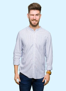 Yakışıklı delikanlı seksi bir ifadeyle, neşeli ve mutlu yüzünü kameraya bakarak göz kırpıyor.