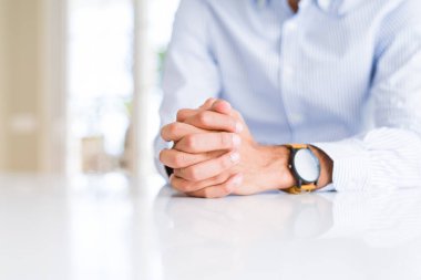 Beyaz masa üzerinde çapraz eller ile adam yakın