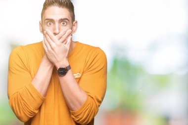 Yakışıklı delikanlı izole arka plan ağız hata için elleriyle kapsayan şok içinde. Gizli kavramı.