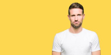 Yakışıklı adam rahat beyaz t-shirt giyen depresif ve kızgın ve korkmuş ağlıyor sıkıntı için endişeleniyorum. Üzgün ifade.