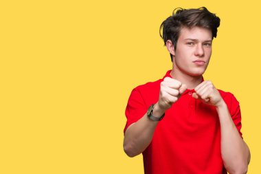 İzole arka plan kum yumruk dövüşü, saldırgan ve kızgın saldırı, tehdit ve şiddet üzerine kırmızı t-shirt giyen genç yakışıklı adam