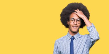 El hareketi ile kendine güvenen dokunaklı saç gülümseyerek, çekici poz gözlüklü afro saçlı genç Afro-Amerikan iş adamı
