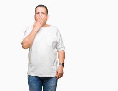 Orta yaş Arap adam wearig beyaz t-shirt izole arka plan üzerine esneme sıkılmış kapsayan ağız el ile yorgun. Restless ve uyku hali.