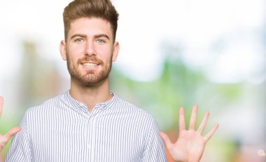 Genç yakışıklı adam kendini beğenmiş ve mutlu bir şekilde gülümserken on numarayı işaret ediyor..