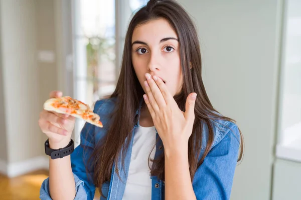 Piękna Młoda Kobieta Jedząca Kawałek Pysznej Pizzy Pokrywa Usta Ręką — Zdjęcie stockowe
