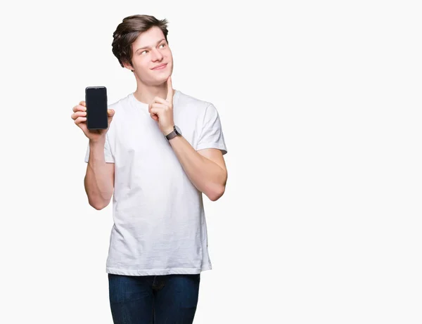 Młody Człowiek Pokazywanie Ekranu Smartfona Białym Tle Poważne Twarz Myślenia — Zdjęcie stockowe