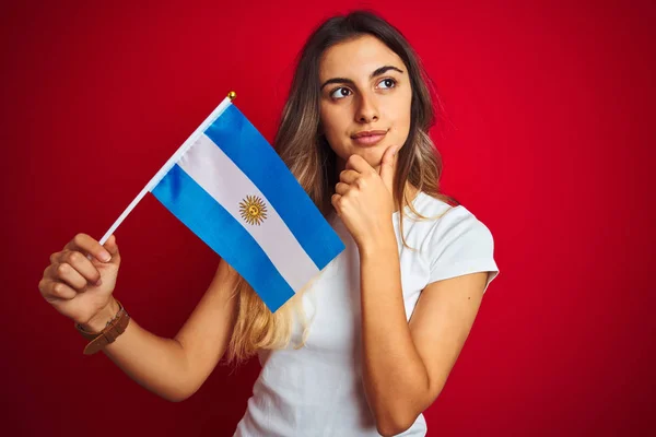 Joven Hermosa Mujer Sosteniendo Bandera Argentina Sobre Fondo Rojo Aislado — Foto de Stock