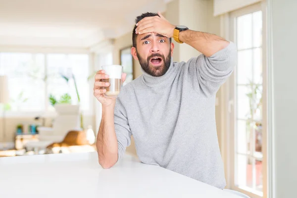 Handsome hispanic man drinking a cup of coffee stressed with hand on head, shocked with shame and surprise face, angry and frustrated. Fear and upset for mistake.