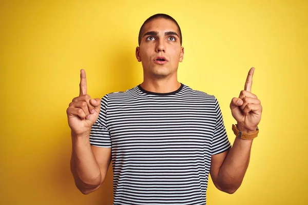 Jonge Knappe Man Draagt Gestreepte Shirt Gele Geïsoleerde Achtergrond Verbaasd — Stockfoto