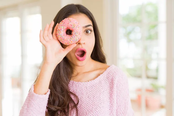 Hermosa joven mujer mirando a través de rosquilla en el ojo con —  Fotos de Stock