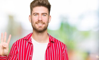 Yakışıklı delikanlı gösterilen ve parmakları ile işaret kırmızı gömlek giymiş dört kendinden emin ve mutlu gülümseyerek iken numara.